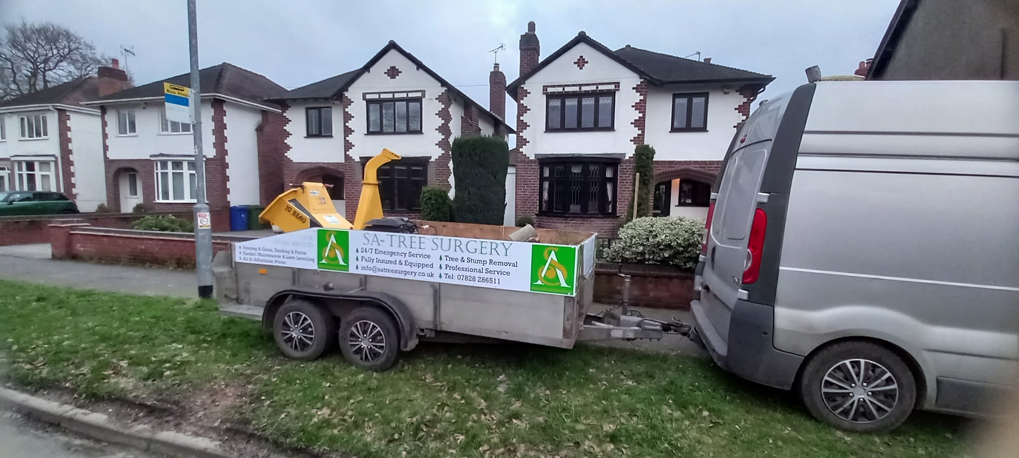 SA-Tree Surgery van and chipper trailer parked on a residential street