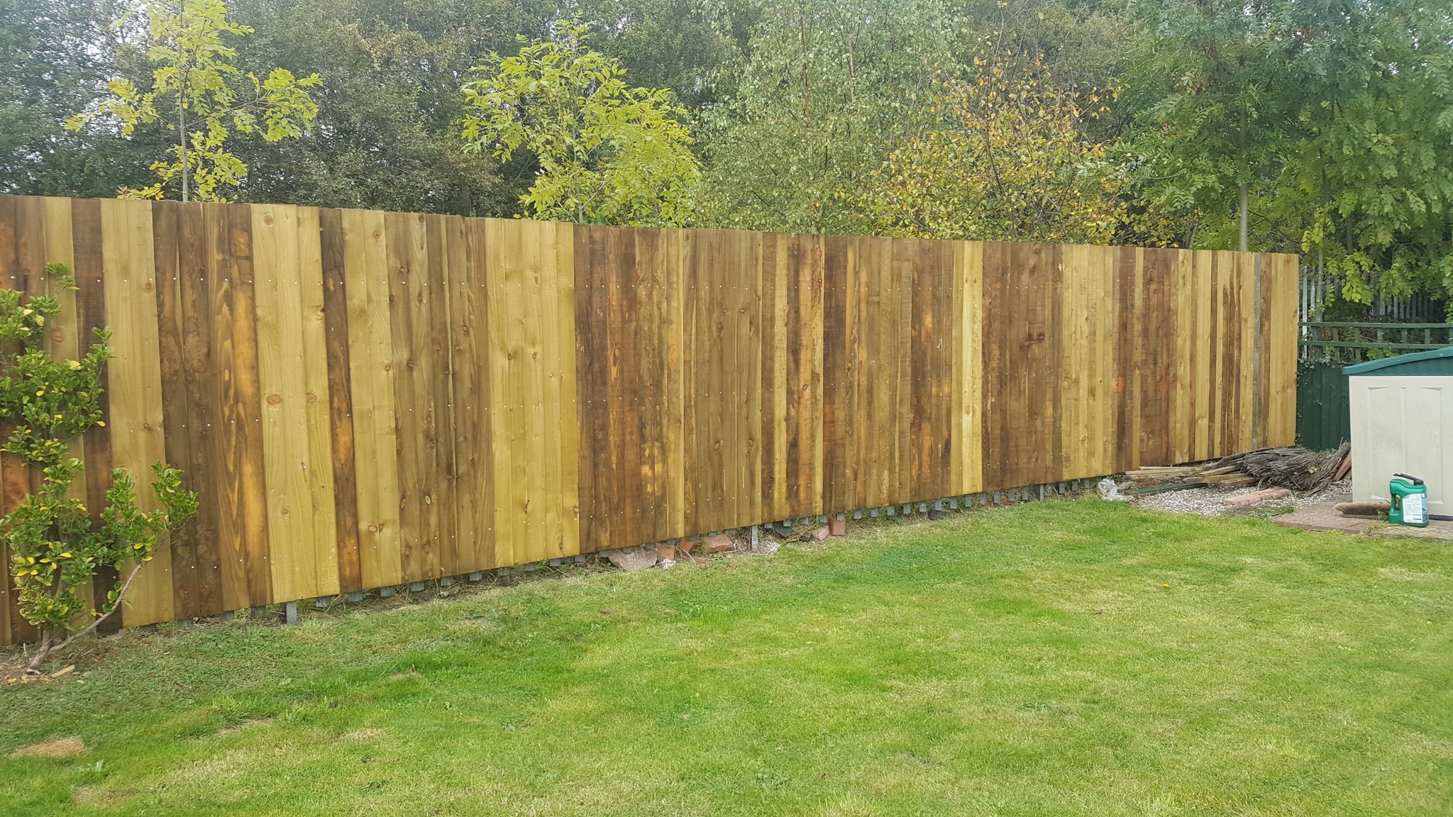 Long new close-board fence along a lawn